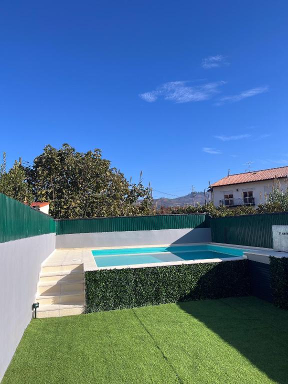 a swimming pool in a yard with green grass at Casa do Carriço in Peso da Régua