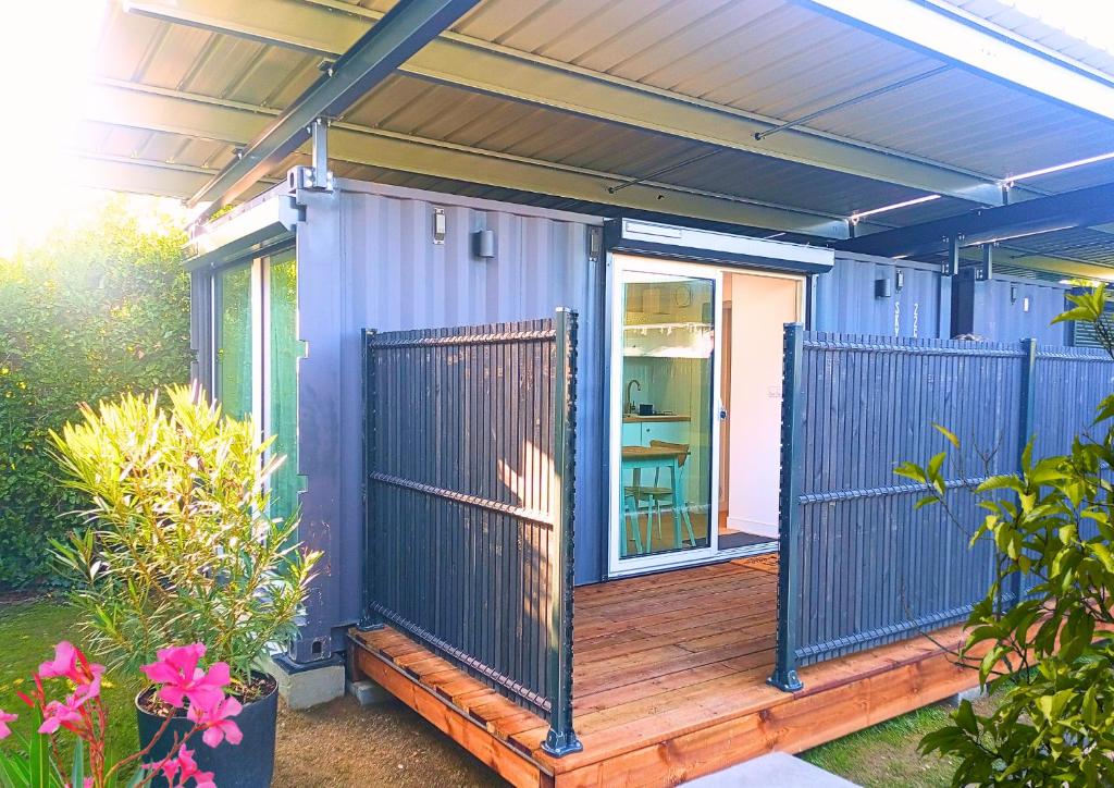 une maison violette avec une terrasse en bois et un portail dans l'établissement La Promenade des 2 Pins - Chic, à Poisat