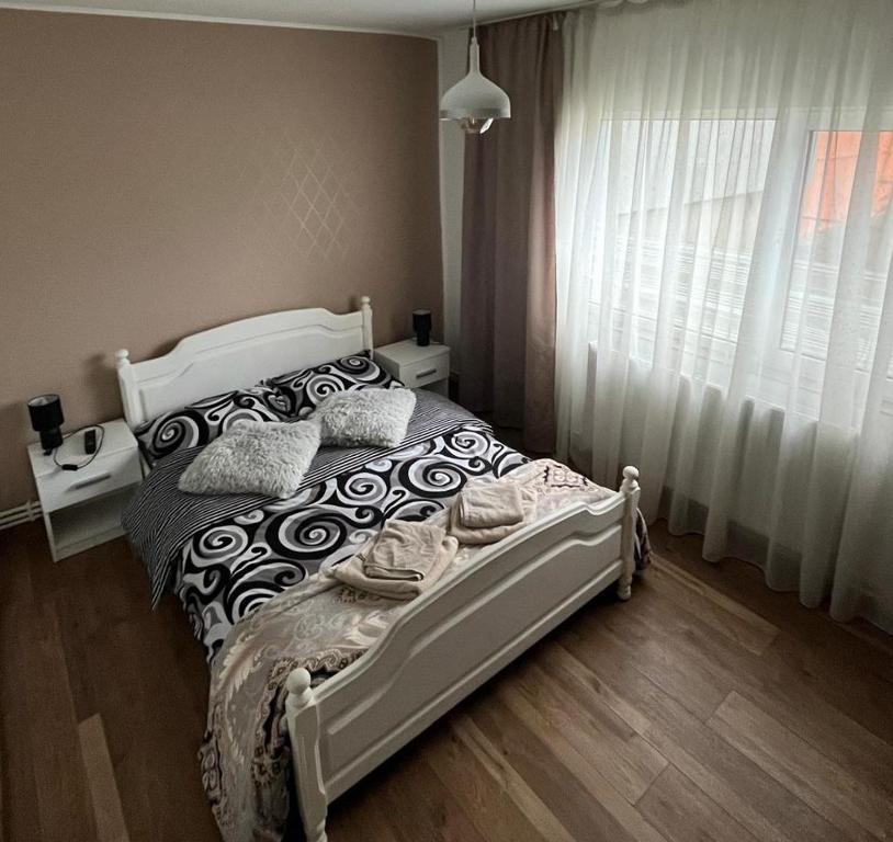 BuzăuにあるCozy Apartmentの白いベッドと窓のある寝室