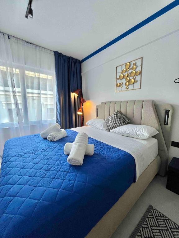 a bedroom with a blue and white bed with towels on it at Voulis 45 Plaka Suite by Zeussuites in Athens