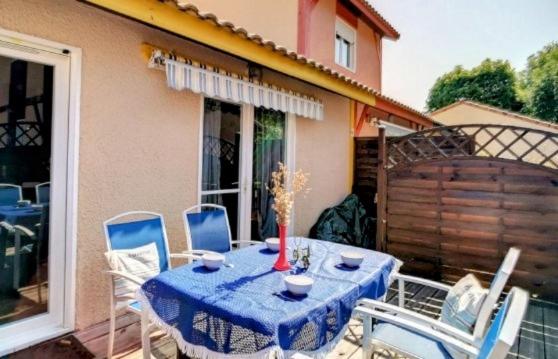 une table et des chaises bleues sur une terrasse dans l'établissement Villa Maëlyssia - Les villas du lac, à Soustons
