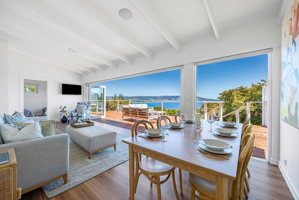 a dining room with a table and a couch at The Peak of Mt Martha Spa and Sunset Views in Mount Martha