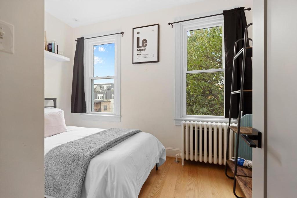a bedroom with a bed and two windows at H St DC Haven 4-BR Homestay in Washington, D.C.