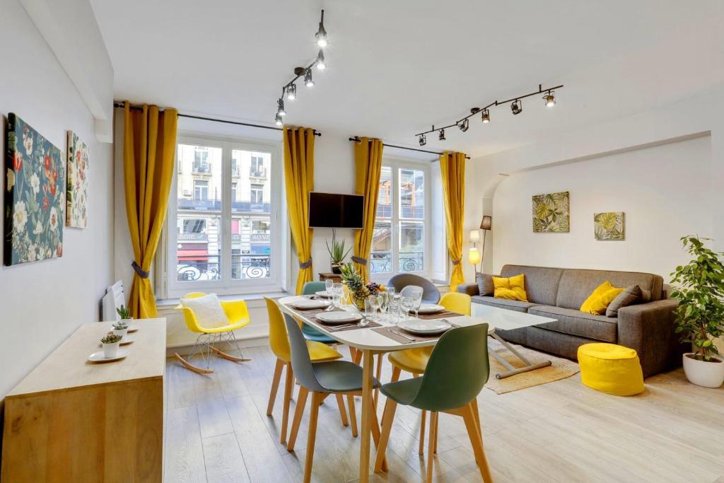 un salon avec une table et des chaises jaunes dans l'établissement 215 Suite Esprit Nature - Superb apartment, à Paris