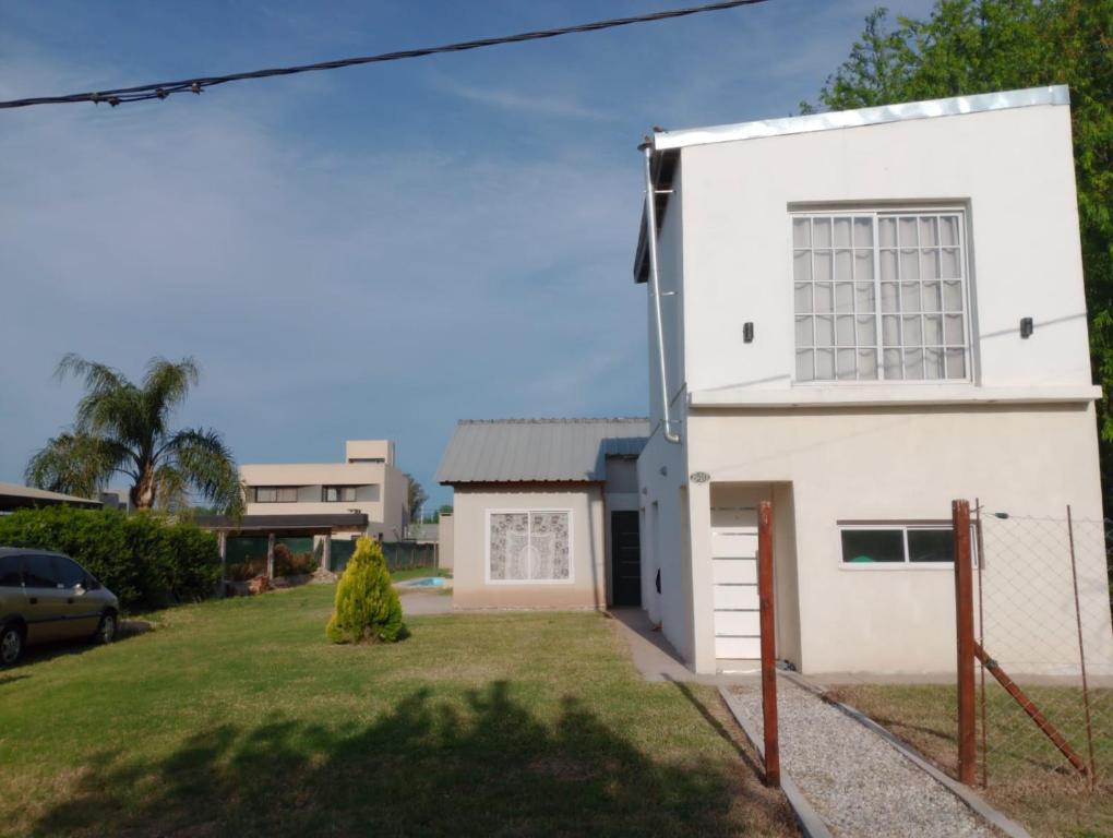 a white house with a yard at Capibara Matero in Roldán