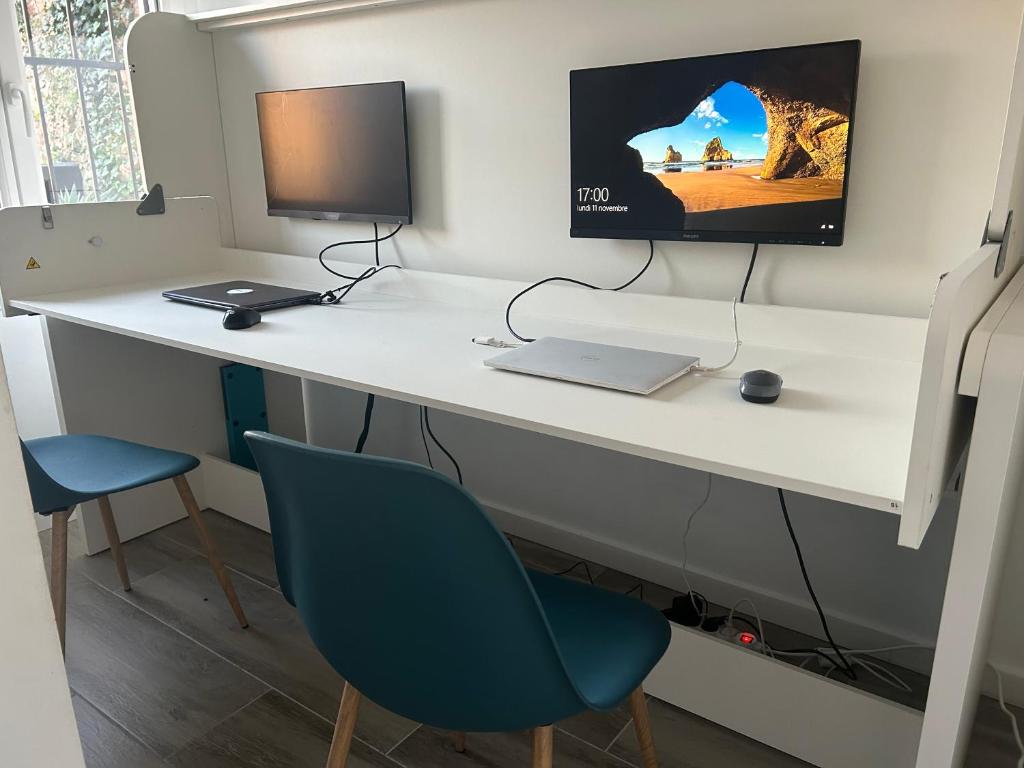 a desk with a laptop and a monitor on it at Canyelles BBQ Apartment in Lloret de Mar