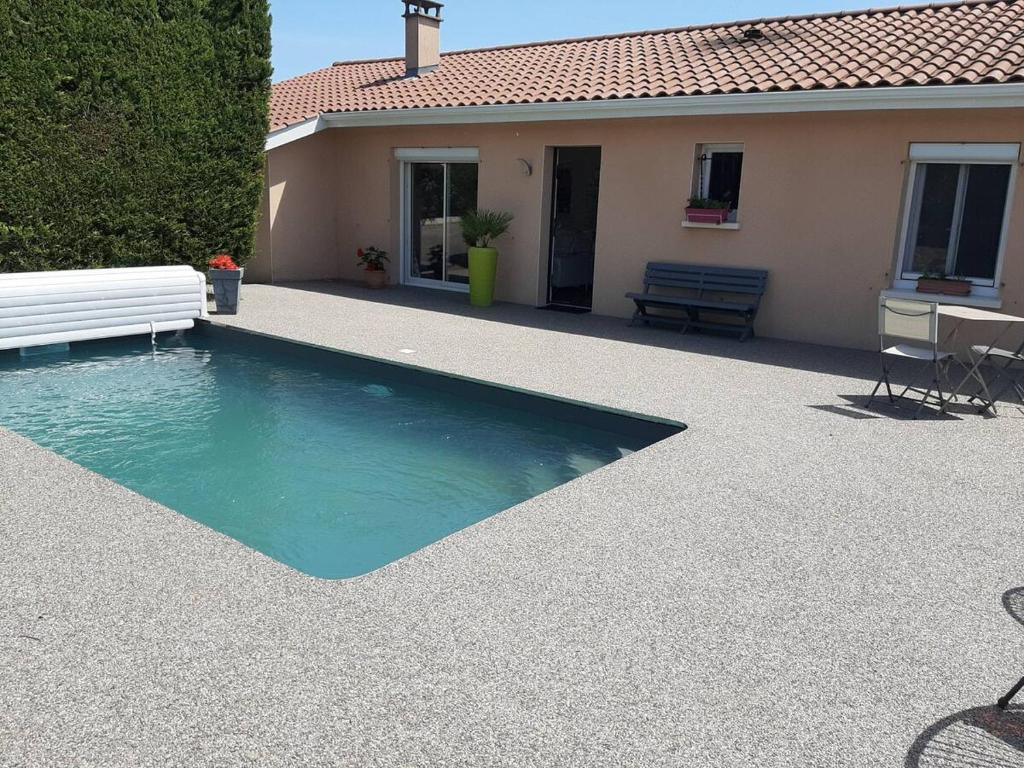 une piscine avec un banc à côté d'une maison dans l'établissement Chambre Maeva chez Laurent, à Chassagny