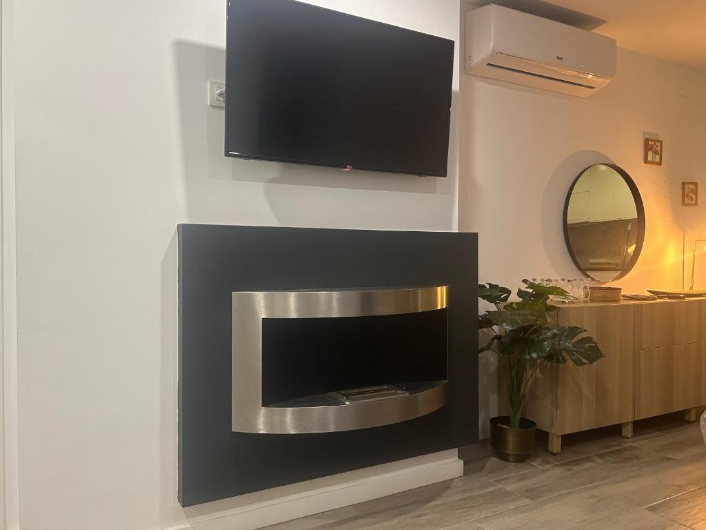 a fireplace with a flat screen tv on a wall at Canyelles BBQ Apartment in Lloret de Mar