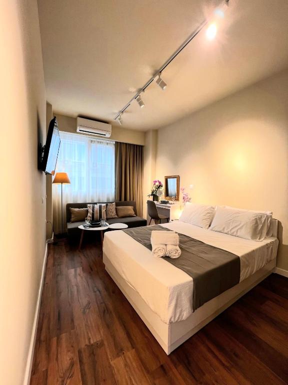 a bedroom with a large bed and a couch at 70 steps studio A, 50 meters from Dimokratias metro station in Thessaloniki