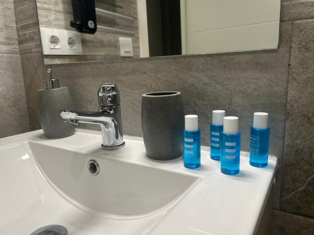 a bathroom sink with three bottles ofodorizers on it at Canyelles BBQ Apartment in Lloret de Mar