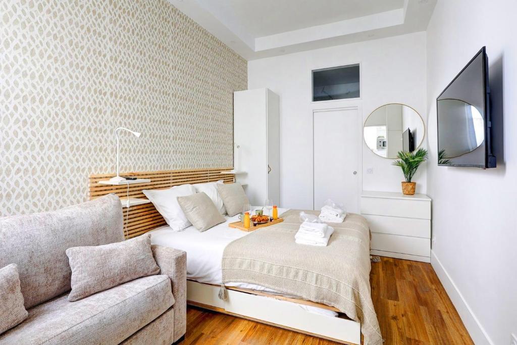 une petite chambre avec un lit et un canapé dans l'établissement 402 Suite Netter - Superbe Studio à Paris, à Paris