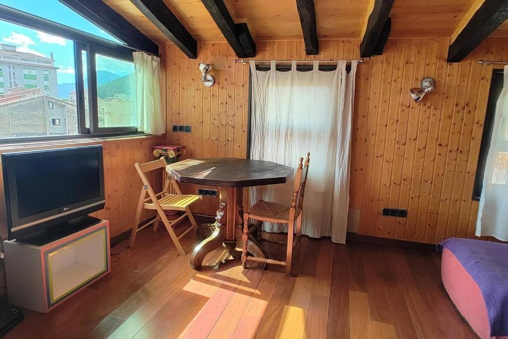 a dining room with a table and a tv at TAO casa WOOD apartamentos in Olot