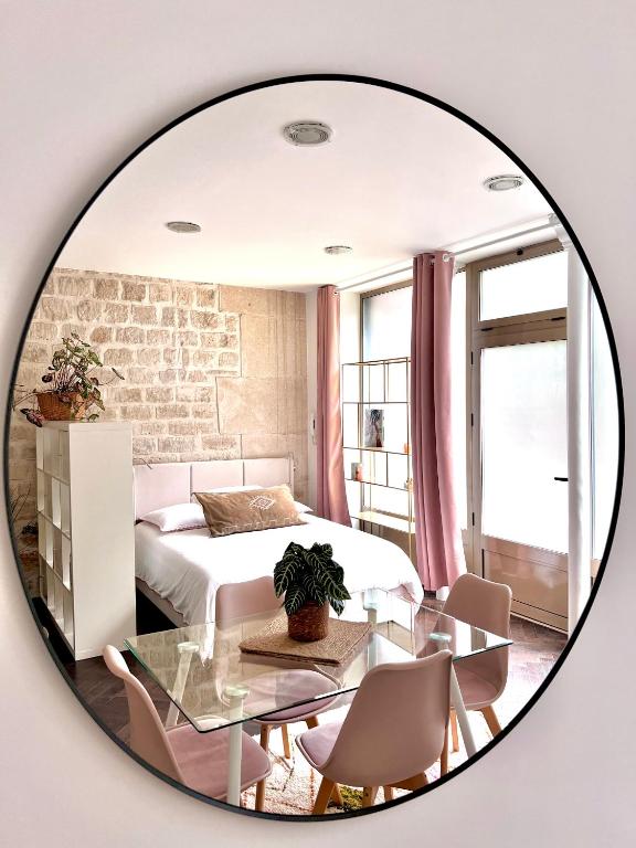 une chambre avec un lit, une table et un miroir dans l'établissement Canal St Martin Miss Dodu, à Paris