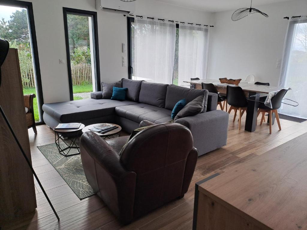 un salon avec un canapé et une table dans l'établissement Maison neuve à 2 pas des plus belles plages de Douarnenez - Classé Meublé de Tourisme 3 étoiles, à Kerlaz