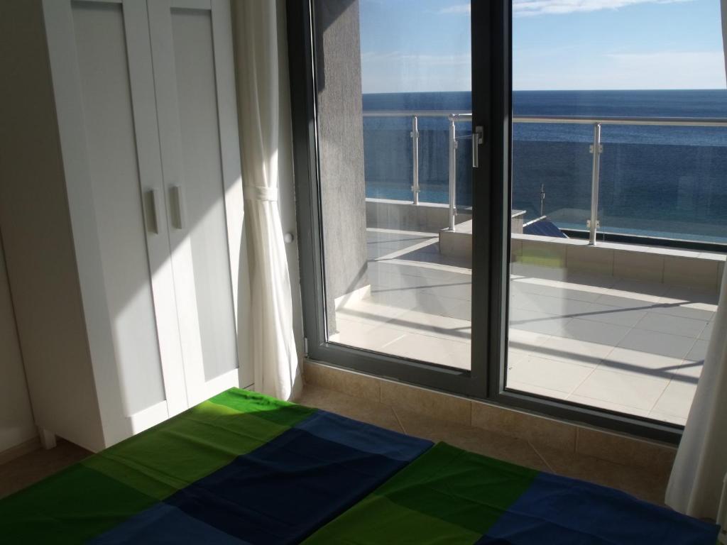 a bedroom with a window with a view of the ocean at The Beach House in Sozopol