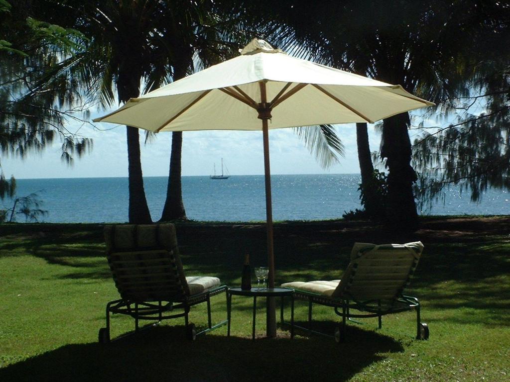 two chairs and a table with an umbrella at Beachside Holiday Units in Bowen