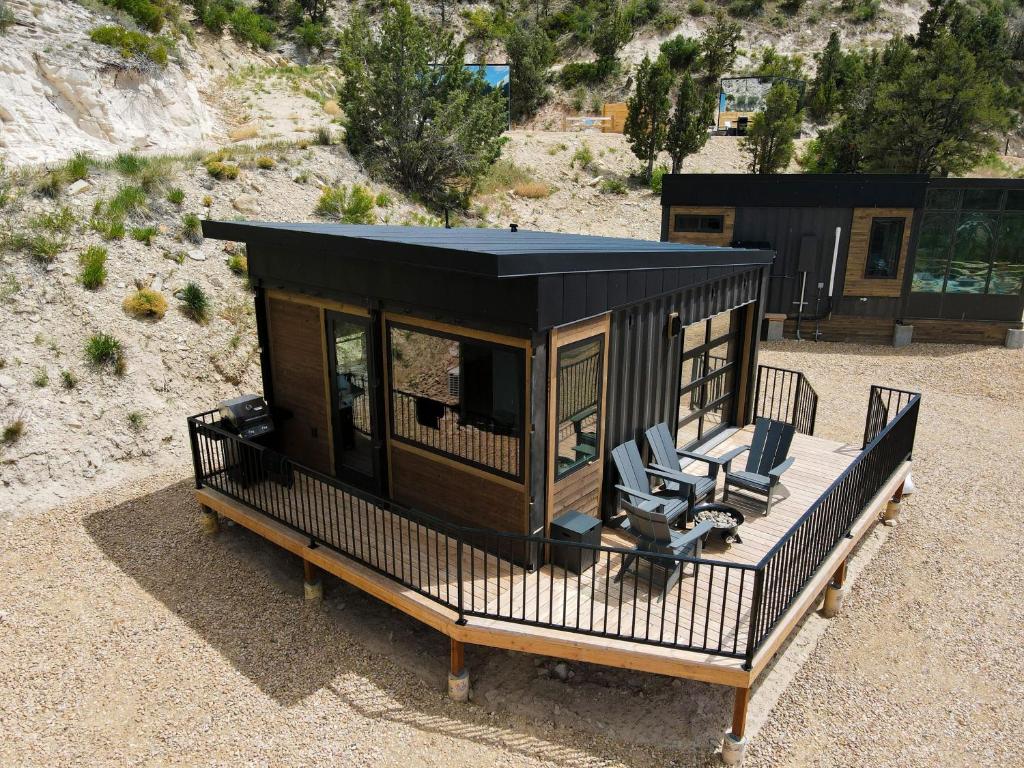 a small cabin with two chairs on a deck at Desert Sand in Orderville