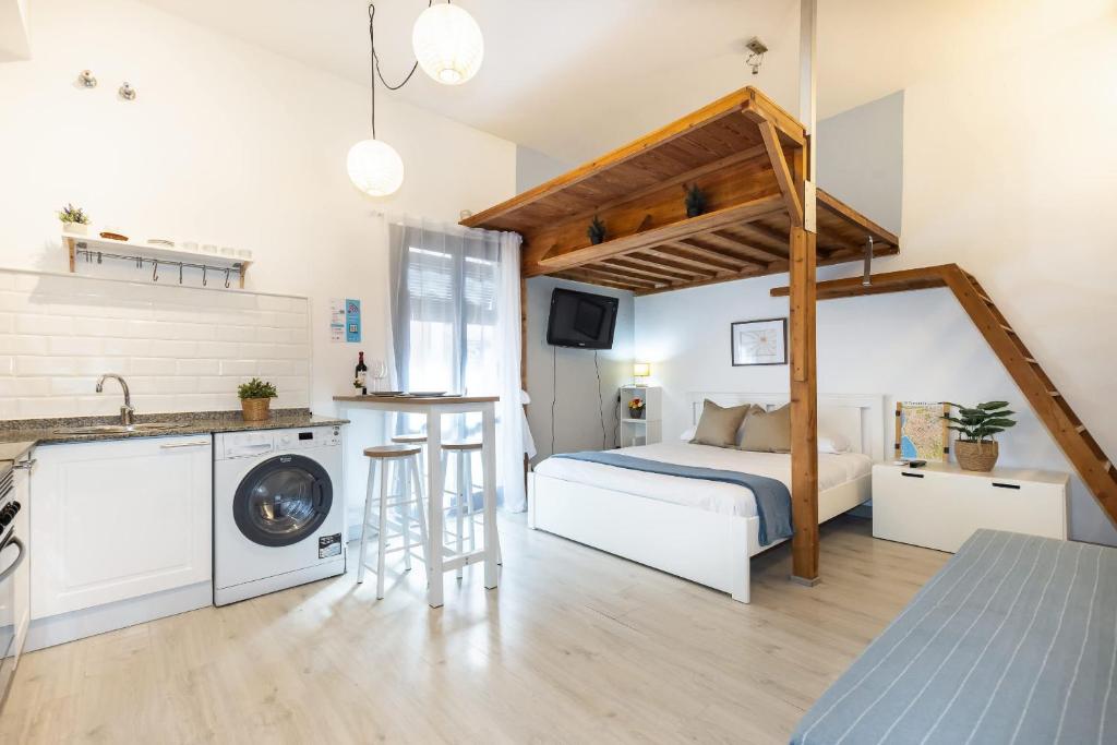 a bedroom with a bed and a kitchen with a sink at Oli by Unik Vacation in Tarragona