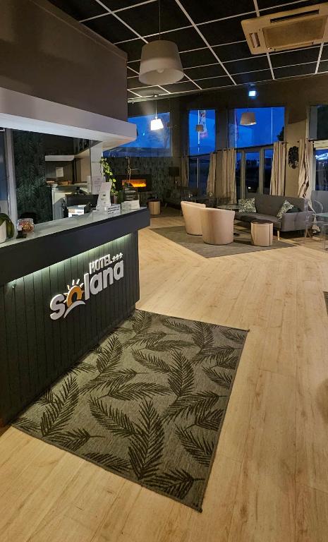 - un hall avec un comptoir et un tapis au sol dans l'établissement Contact Hôtel Solana, Niort MendesFrance, à Niort