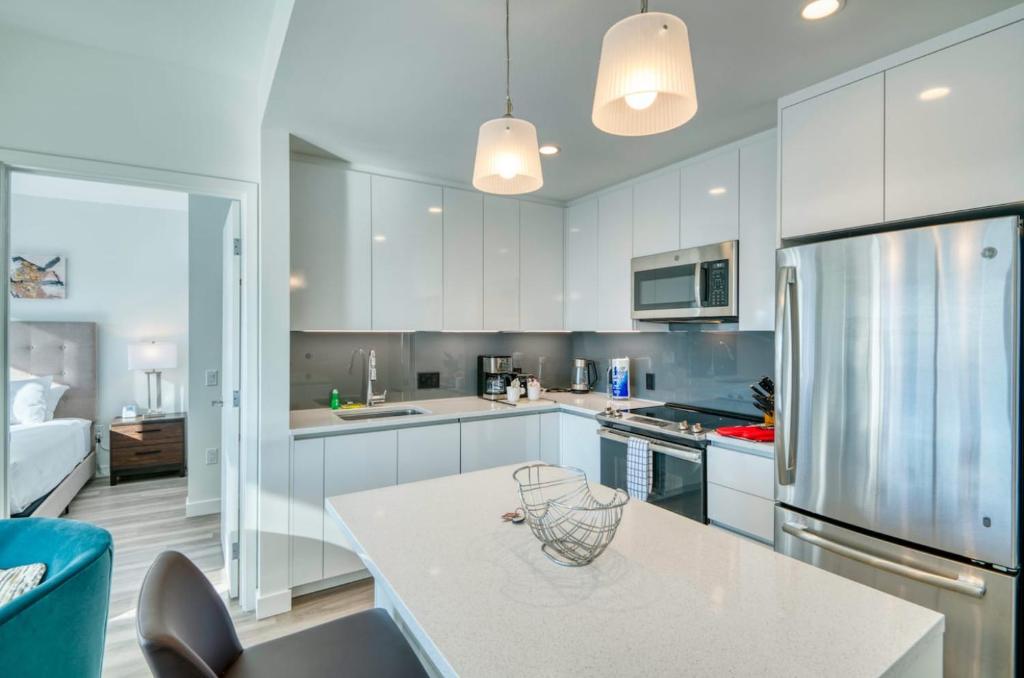 Una cocina con gabinetes blancos y una encimera blanca. en Stunning Apt with City Views, en Boston