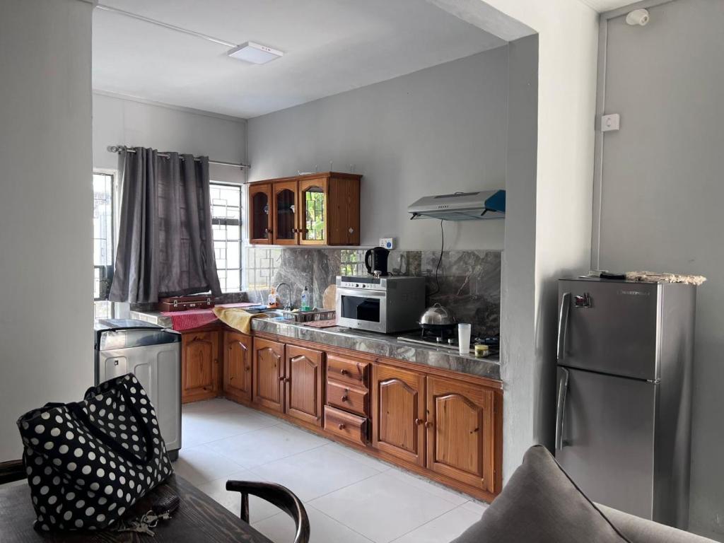 a kitchen with wooden cabinets and a stainless steel refrigerator at 2 pokojový apartmán v Pereybere in Pereybere