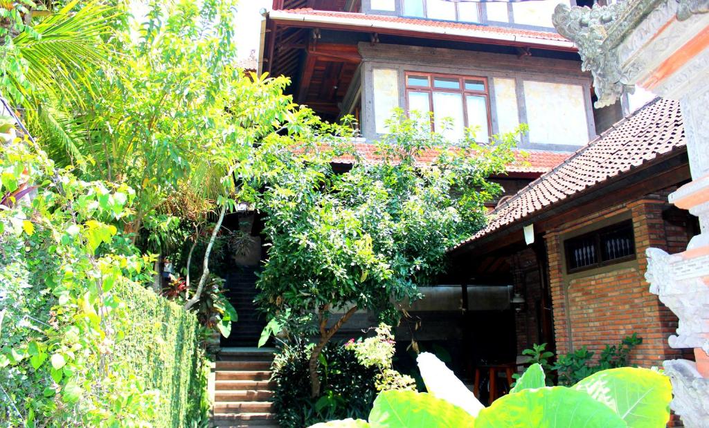 una casa de ladrillo con escaleras y árboles delante de ella en Dewa Bungalows, en Ubud