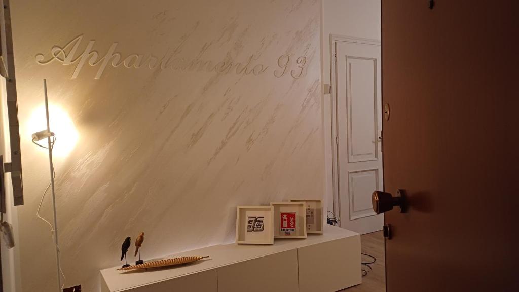 ein Zimmer mit einer weißen Wand und einem Regal mit Büchern in der Unterkunft Appartamento 93 di andrea sonzogni in Castelleone