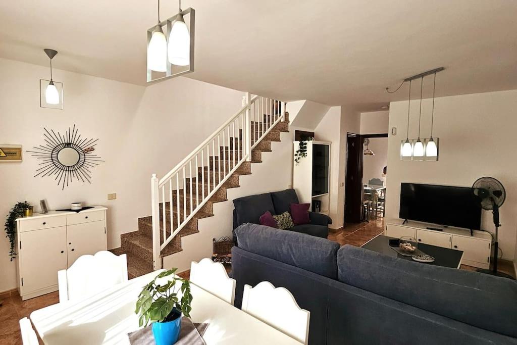 a living room with a blue couch and a staircase at Casa Criso Puerto del Rosario in Puerto del Rosario