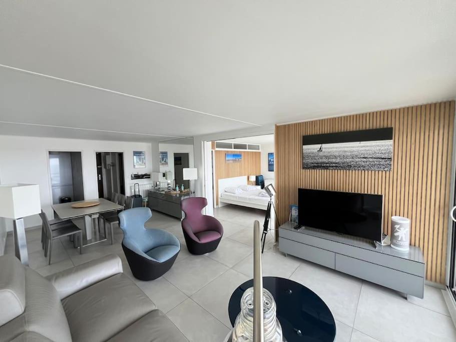 un salon avec un canapé et une télévision dans l'établissement Le Touquet Paris-Plage face mer, prox rue St Jean, à Le Touquet-Paris-Plage