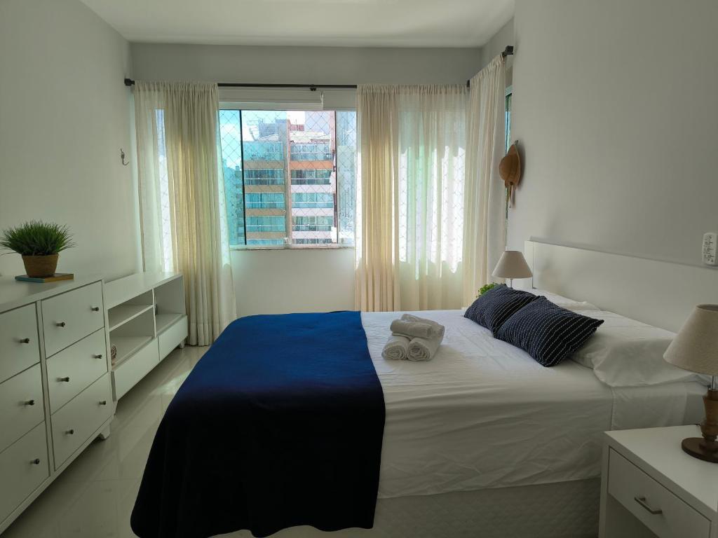 Un dormitorio con una cama grande y una ventana. en Apartamento uma quadra do mar, melhor localização, en Capão da Canoa