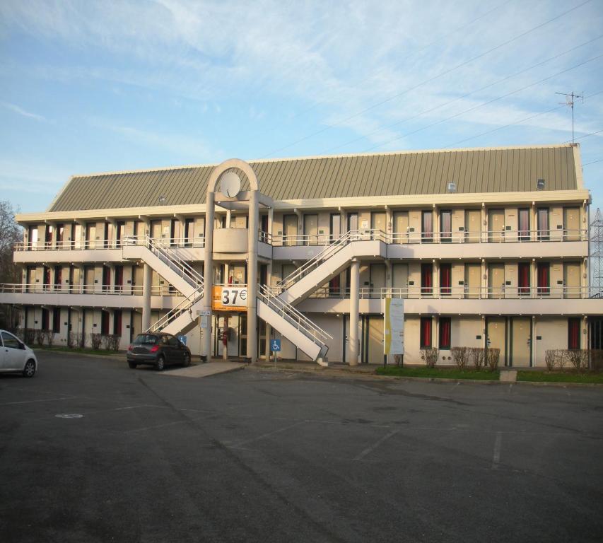 un gran edificio con una escalera de caracol delante de él en Premiere Classe Dreux, en Dreux