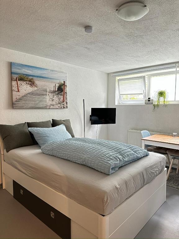 a bed in a bedroom with a desk and a bed sidx sidx sidx at Ferienwohnung Nähe Stadtmitte in Friedrichshafen