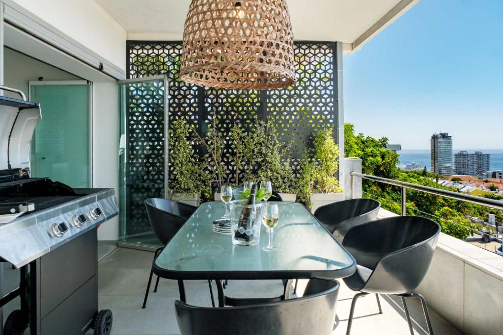 a kitchen with a table and chairs on a balcony at Ocean Vue in Cape Town