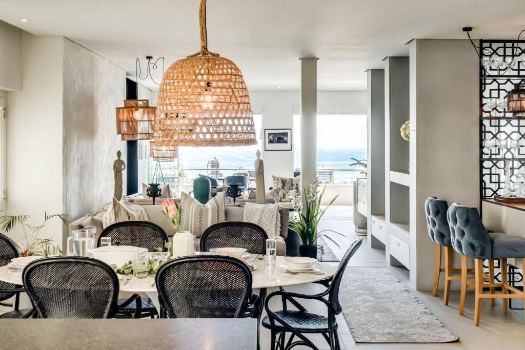 a dining room with tables and chairs and a view of the ocean at Ocean Vue in Cape Town
