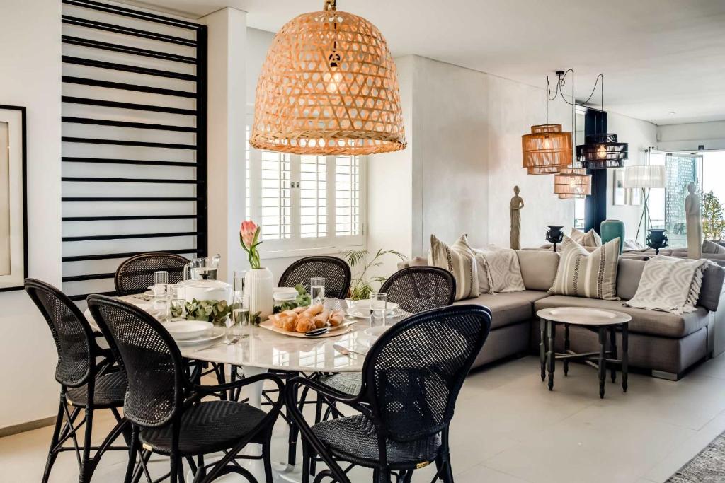 a dining room with a table and chairs and a couch at Ocean Vue in Cape Town