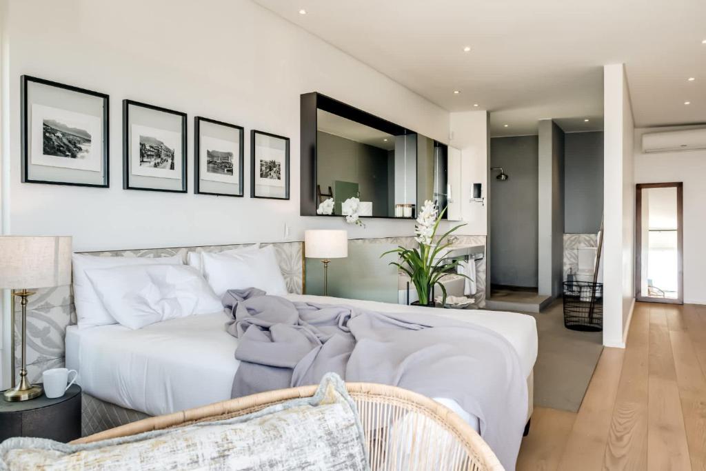 a bedroom with a white bed and a living room at Ocean Vue in Cape Town
