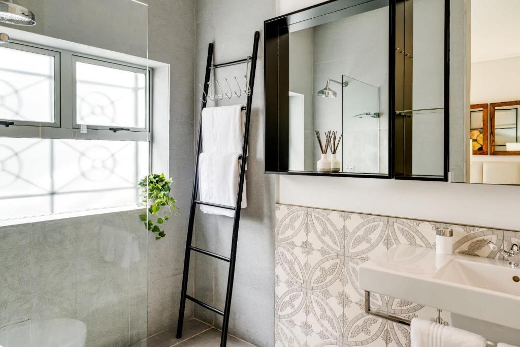 a bathroom with a sink and a mirror at Ocean Vue in Cape Town