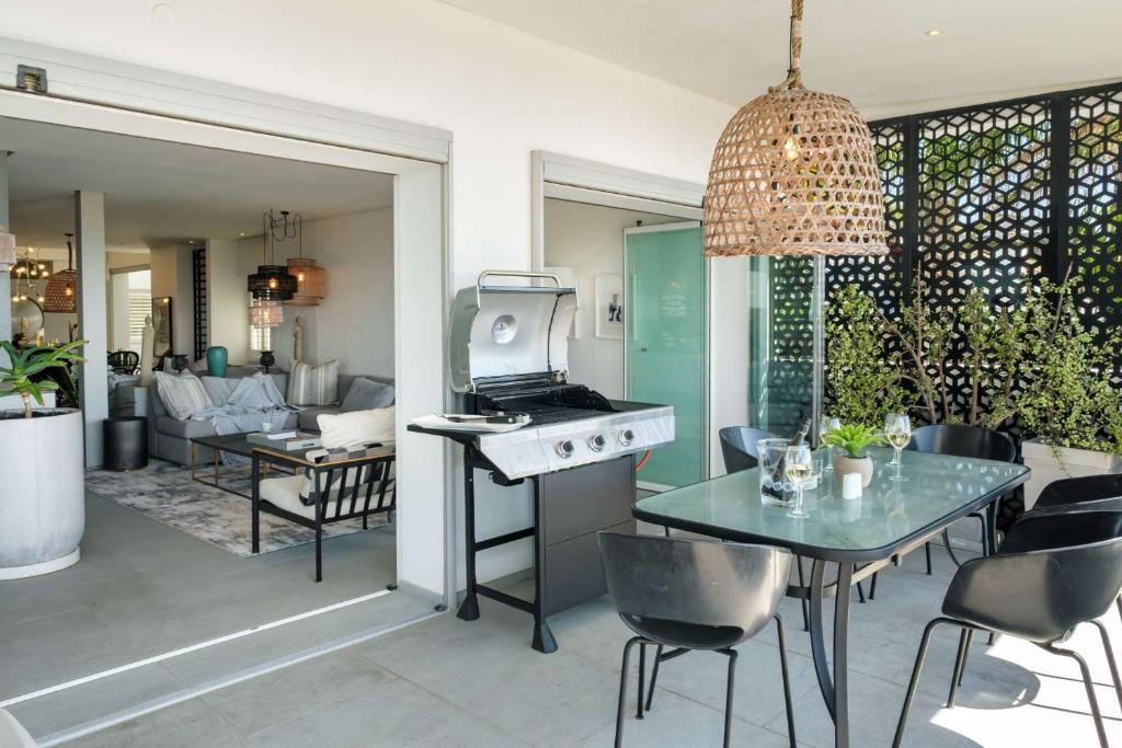 a kitchen and living room with a table and a stove at Ocean Vue in Cape Town