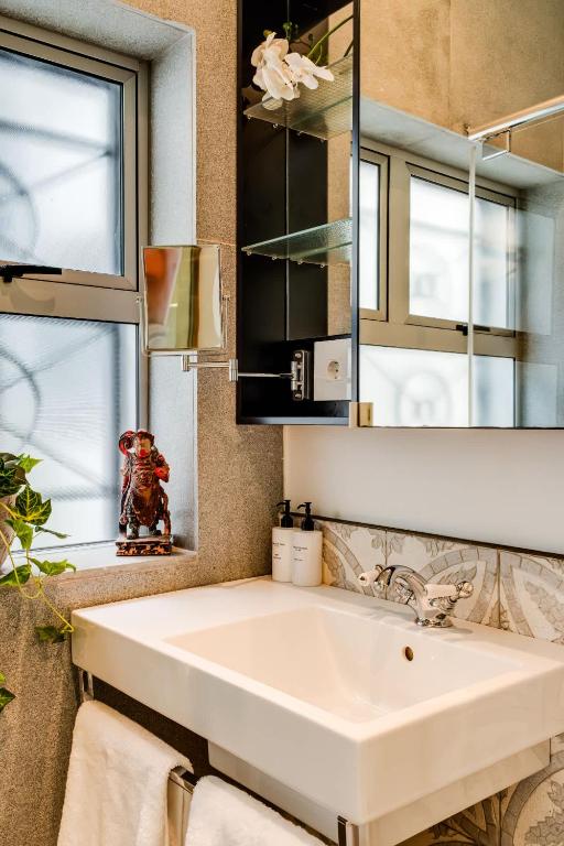 a bathroom with a white sink and a mirror at Ocean Vue in Cape Town