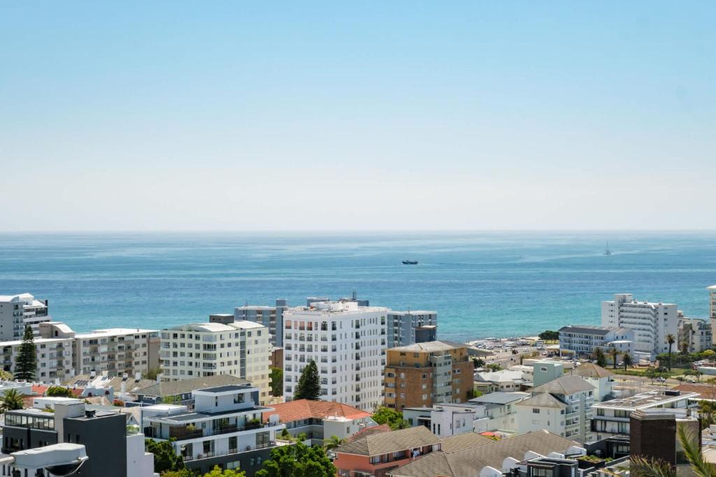 a city with buildings and the ocean in the background at Ocean Vue in Cape Town