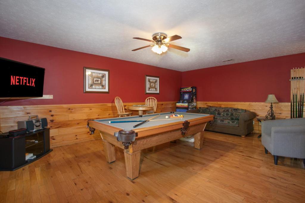 a living room with a pool table and a ceiling fan at Bears Corner w/ Hot Tub, Arcade & Community Pool! in Gatlinburg