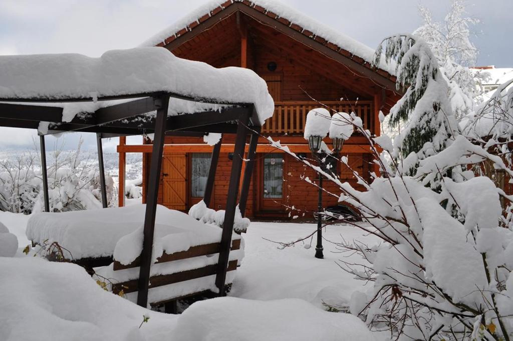 une cabane en rondins avec de la neige dans la cour dans l'établissement Chalet Eras, Belle vue lac, Sauna, Wifi, à Gérardmer