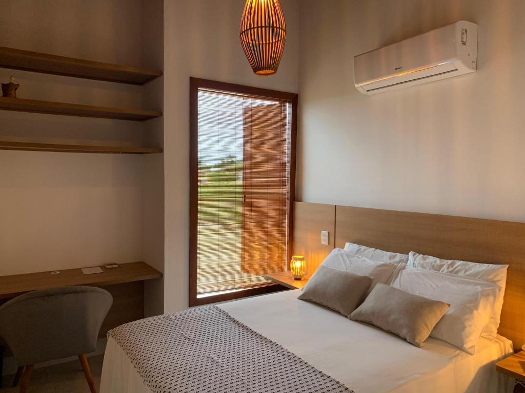 ein Schlafzimmer mit einem weißen Bett und einem Fenster in der Unterkunft Casa Branca Maraú in Taipu