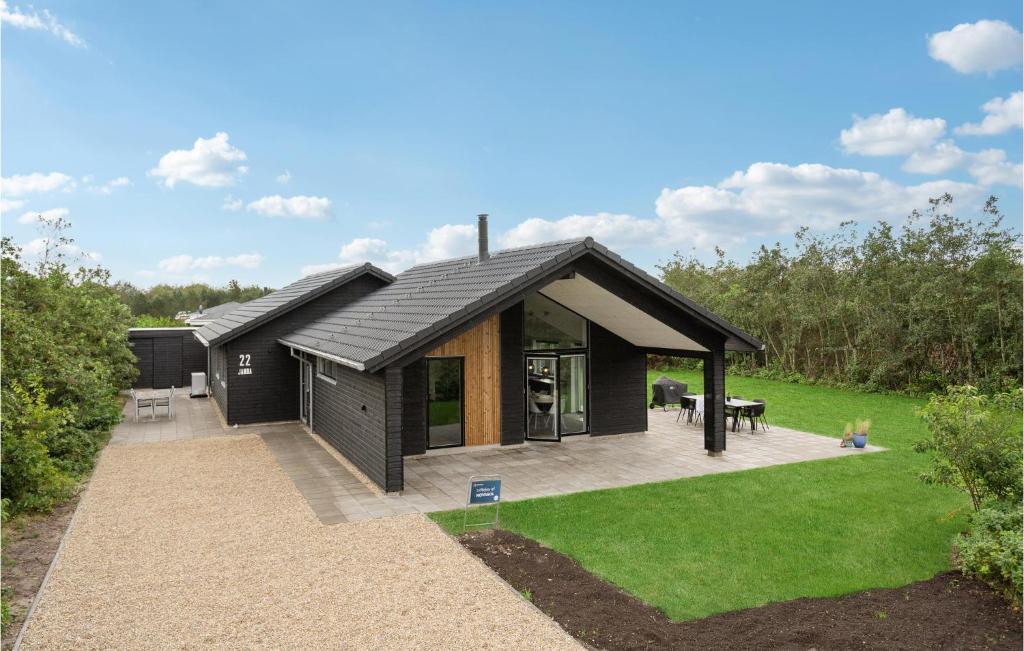 a small black house with a patio and grass at Awesome Home In Tarm With Kitchen in Tarm