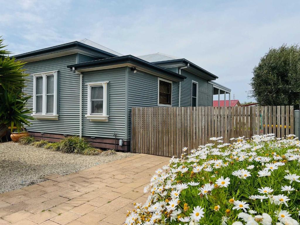 een blauw huis met een hek en bloemen bij Saltwater Bungalow - WiFi in Robe
