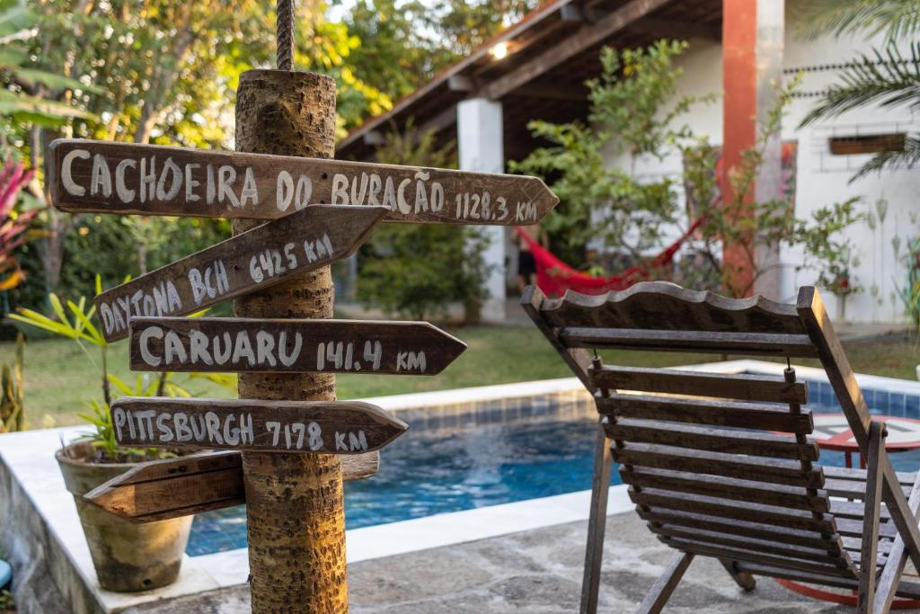 un panneau à côté d'une chaise près d'une piscine dans l'établissement Casa Urucum - Recife - Casa Ecológica, à Camaragibe
