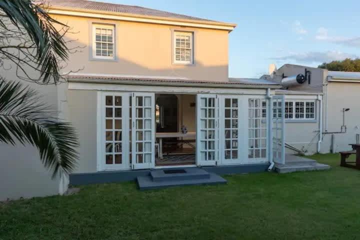 a house with white doors and a yard at Langebaan 4 Bedroom Holiday Home in Langebaan