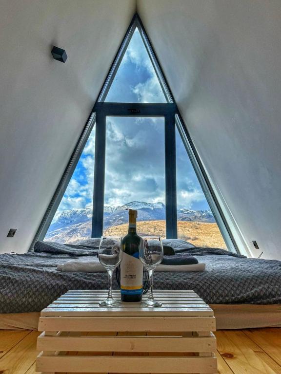 a bottle of wine on a table in front of a window at Kucica na Brdu in Brda