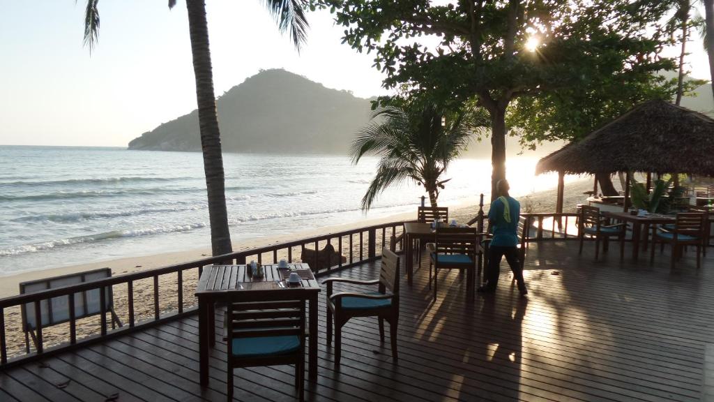 a person walking on a deck next to the beach at PingChan Koh Phangan Beachfront Resort in Thong Nai Pan Yai