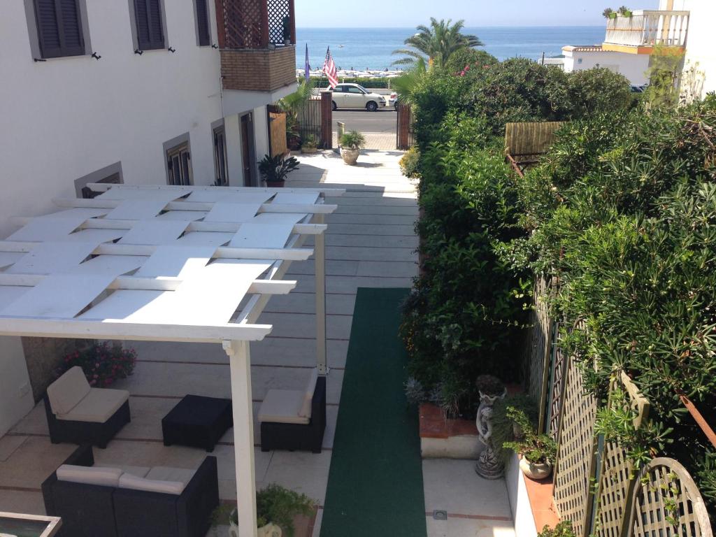 a balcony with a white table and chairs and the ocean at Hotel La Rosetta Scauri in Scauri